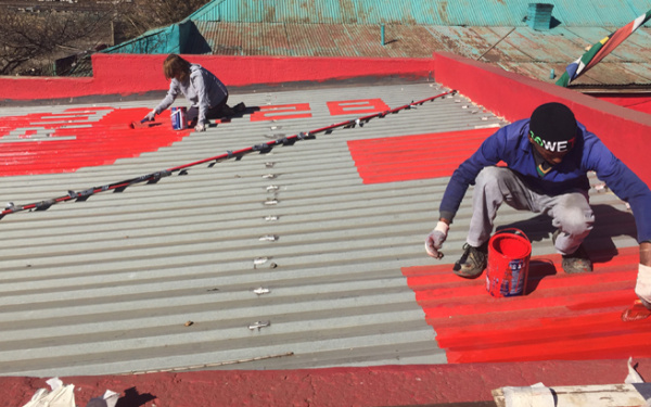 People drawing the word "one" on a roof