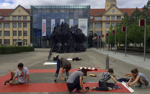 Personen malen das Wort "unites" auf dem ZKM_Vorplatz