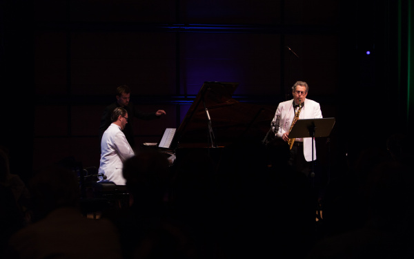 A man at the piano, another one playing saxophone