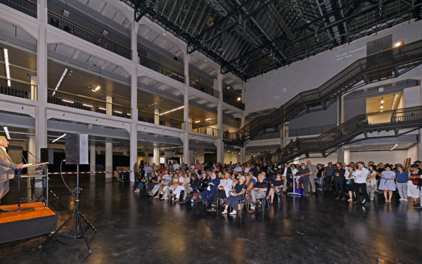 A man standing in front of a sitting crowd