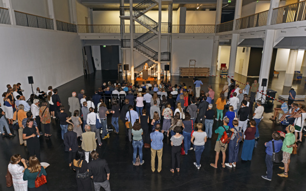 A man standing in front of a sitting crowd