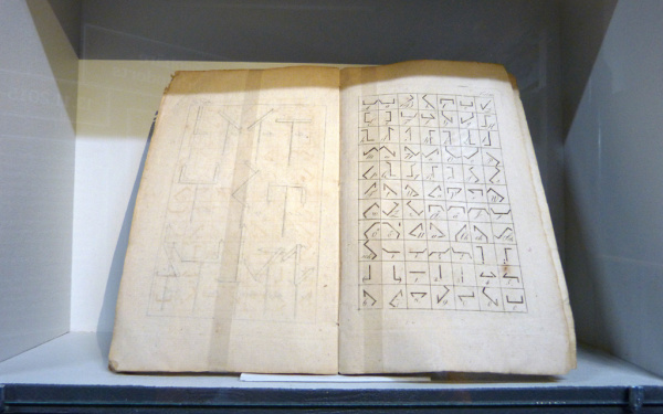 Ein altes, aufgeschlagenes Buch mit Zeichen