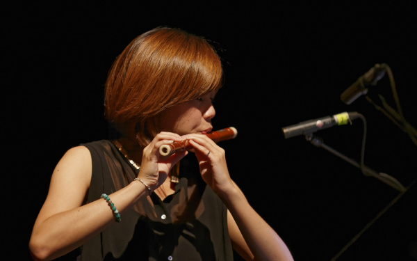 A woman playing a kind of transverse flute