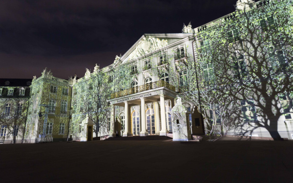 Projected green trees on the palace facade