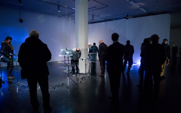 People stand in a blue room with different gadgets