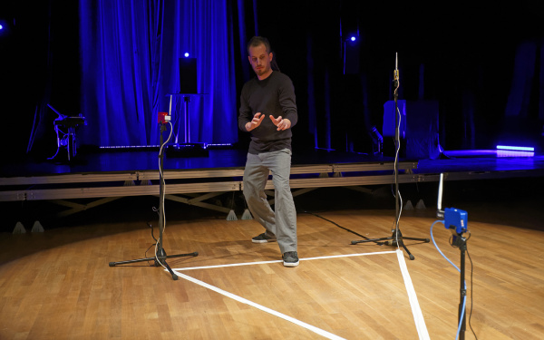 A man stands in a with tape drawn triangle