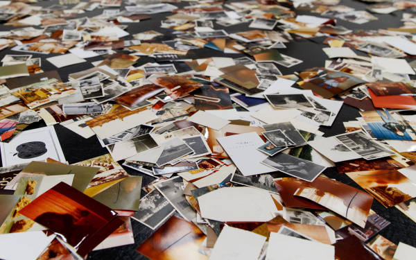 Eine Installation von Dieter Hacker. Auf dem Boden des Ausstellungsraums sind farbige Fotografien verteilt.