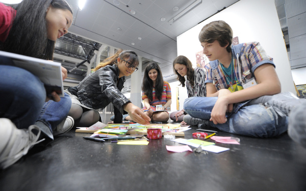Eine Gruppe von Jugendlichen arbeitet in einer ZKM Ausstellung an ihrer Visualisierung sozialer Netzwerke.