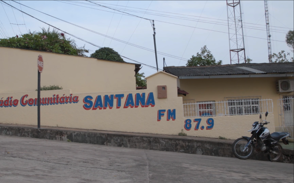 Zu sehen ist eine Häuserwand auf der steht "Radio Comunitaria Santana FM 87.9".