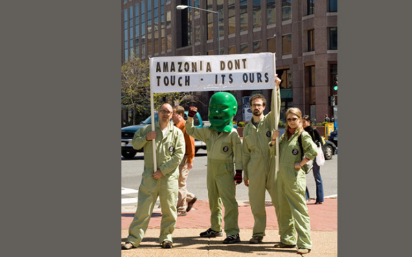 Vier Menschen halten ein Banner hoch auf dem steht "Amazonia dont touch - its ours"