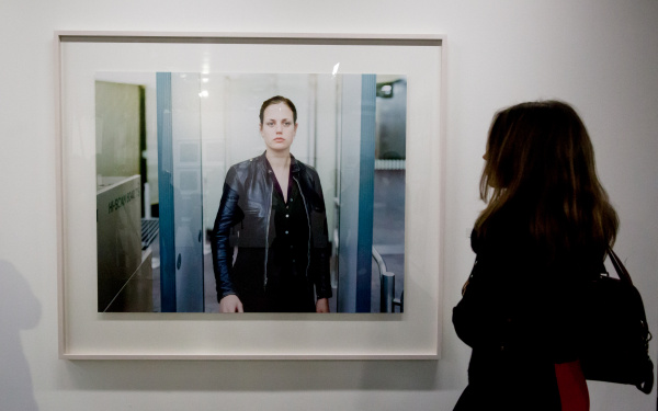 A woman ist standing in front of a photograph