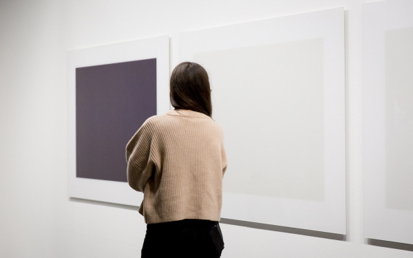 A Woman stands in front of an artwork