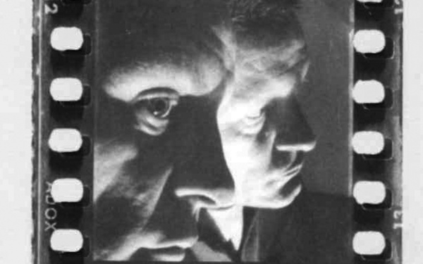 Die Schwarz-Weiß-Fotographie zeigt ein Portrait Helmut Heißenbüttels, der sich seitlich in einem Spiegel spiegelt. 