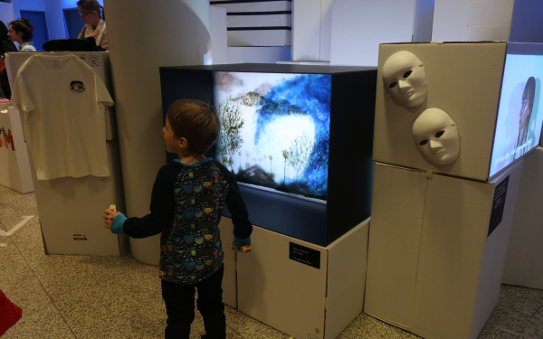 Ein kleiner Junge steht vor einem Fernseher im Rahmen einer Veranstaltung der Kulturakademie.