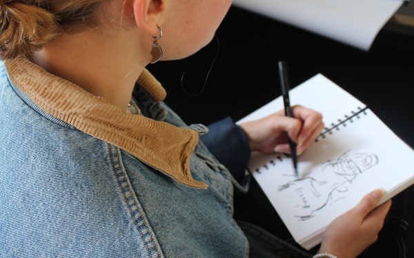 Foto einer jungen Frau beim Zeichnen