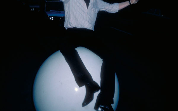 Fotografie von Gerhard Johann Lischka, auf einer großen weißen Kugel sitzend