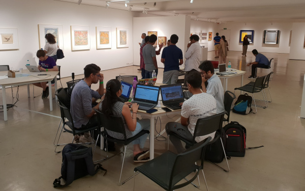 A group of young people sitting at a table in front of their laptops