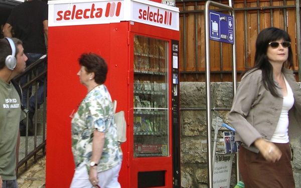 Frau steht auf einem Süßigkeitenautomaten