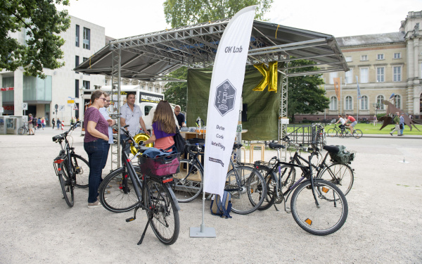 Eine Personengruppe mit Fahrrädern vor dem Spacecraft_ZKM in Karlsruhe.