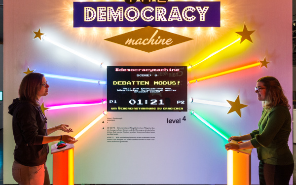 Zwei SpielerInnen spielen »The Democracy Machine!«