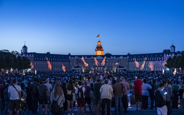 Auf der Fassade des Karlsruher Schlosses erscheinen verschiedene Hände, die zusammen einen bestimmten Sound anstimmen.