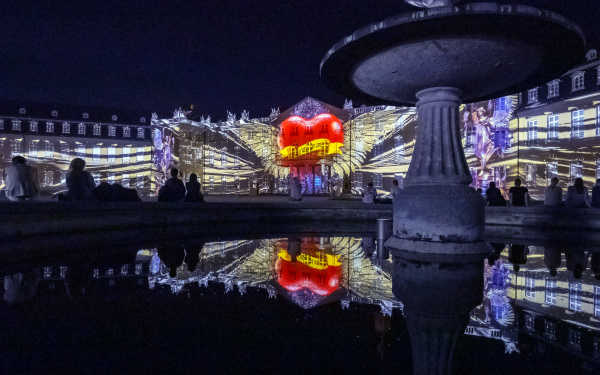 Frei nach dem Motto »Love First« pulsiert ein großes rotes Herz mit Flügeln und Aufschrift auf der Fassade des Karlsruher Schlosses.