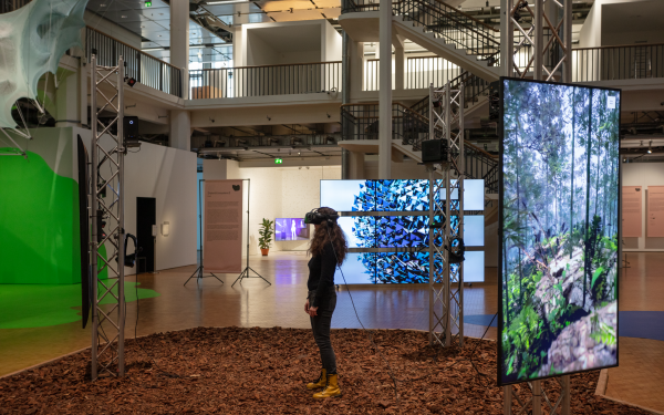 A woman wearing VR goggles in the »BioMedia" exhibition