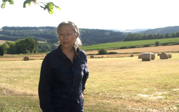 A photo of KIM Soun Gui standing in a field can be seen.