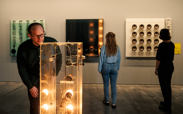 Zu sehen sind drei Personen in der Ausstellung »Walter Giers. Electronic Art«