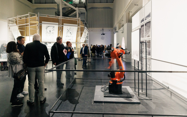 Zu sehen ist ein orangefarbener Roboter in der Ausstellungsfläche Renaissance 3.0.