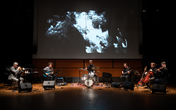 Zu sehen ist die Band »Polytheistic Ensemble« auf einer Bühne mit ihren Instrumenten.