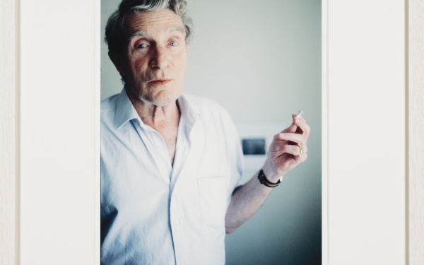 Same morning smoking, what looks like a regular cigarette. On Brion’s pinky his golden seal ring can be seen. Blurred in the background is the black-and-white photograph depicting Burroughs’ blackboard drawings illustrating his lecture The Four Horsemen of the Apocalypse, given at one of the Whole Earth Conferences a little outside of Aix-en- Provence, which also Brion did attend