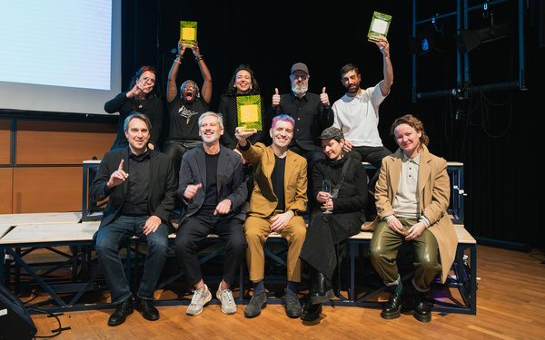 Zu sehen ist ein Gruppenbild mit mehreren Personen, die einen Award halten. 