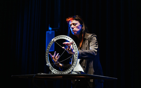 Zu sehen ist eine Person, die auf einer Bühne Musik macht. 