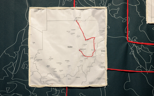 Detailaufnahme einer gestickten Route auf schwarzem Stoffhintergrund.