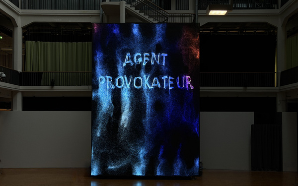 A huge screen displaying the words “Agent Provokateur”.