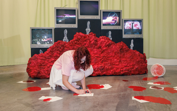 Das Bild zeigt eine Person, die an einer Multimedia-Installation arbeitet.