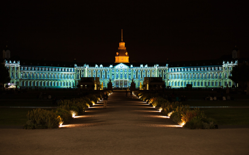 Die Karlsruher Schlossfassade in grün-blauem Licht
