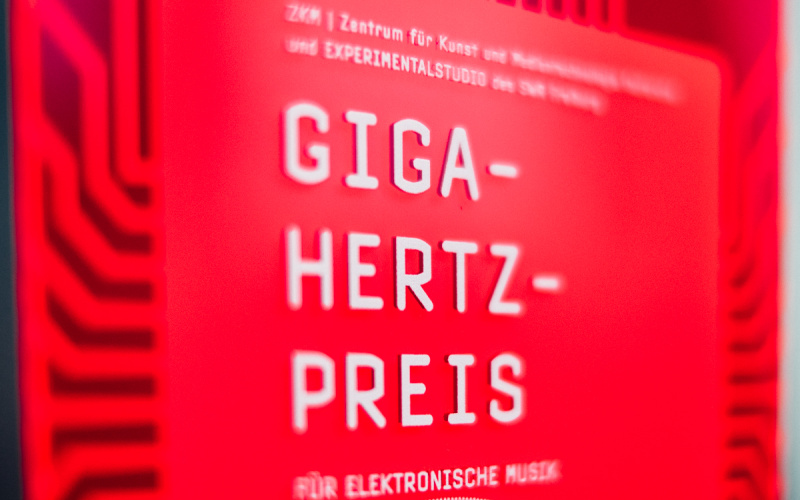 Roter Plakette, auf der mit weißer Schrift "Giga-Hertz-Preis" steht