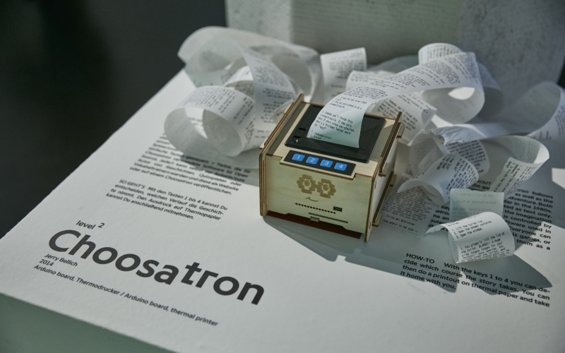 A wooden box with a printer, a four button interface and printed text on a roll