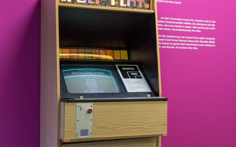 Ein Arcade Automat vor einer violetten Wand