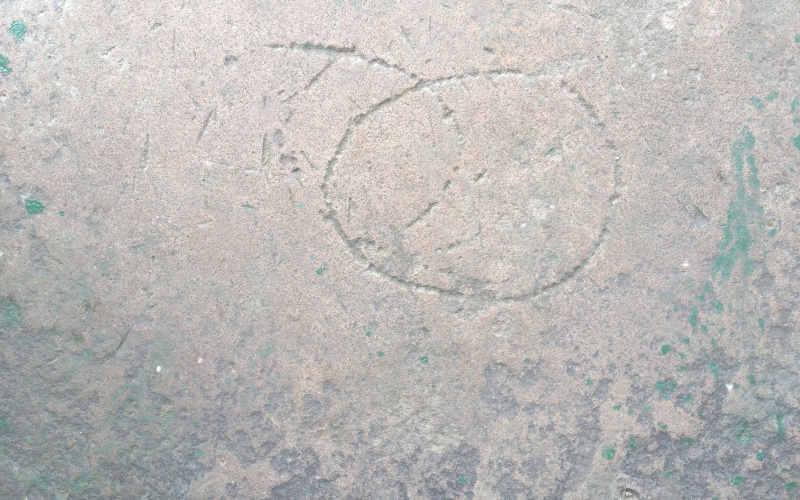 Kreisformen, die auf einer steinernen Oberfläche eingeritzt sind.