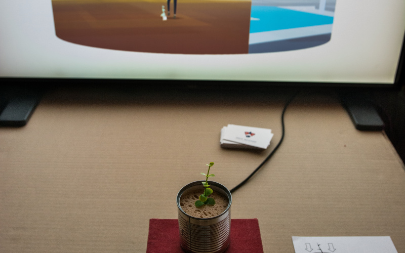Eine Pflanze wächst aus einer Dose die mit einem Bildschirm verbunden ist.