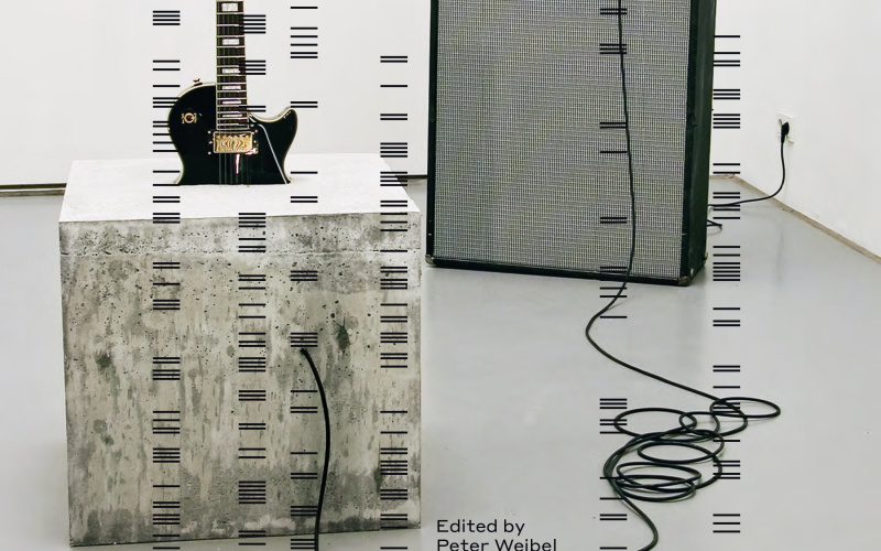Das Cover der Publikation "Sound Art. Sound as a Medium of Art". Zu sehen ist das Kunstwerk von Douglas Henderson, "stop." von 2007 - eine E-Gitarre halb einbetoniert in einem betonwürfel; verbunden mit einem Marshal Verstärker und einer Fender Box.
