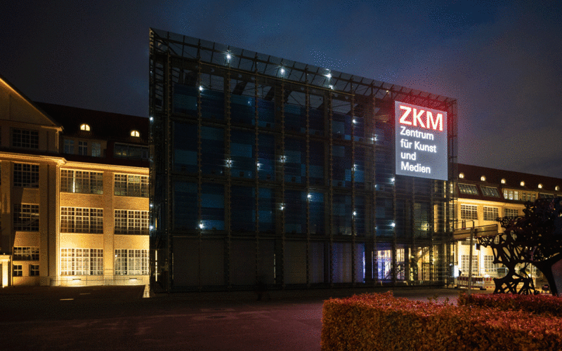 The glass cube of the ZKM sparkles in the dark with bright points of light. An installation by Walter Giers.