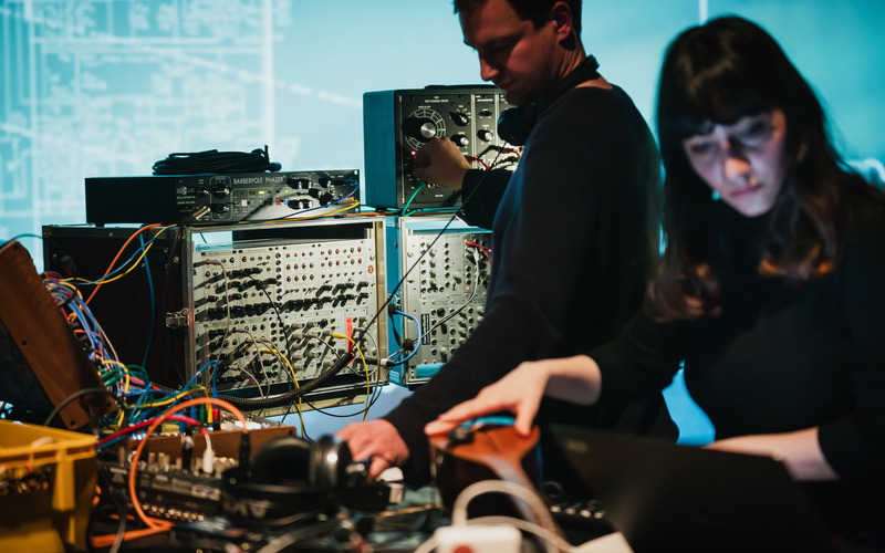 The picture shows two people on a stage producing sounds with the Barberpole Phaser.