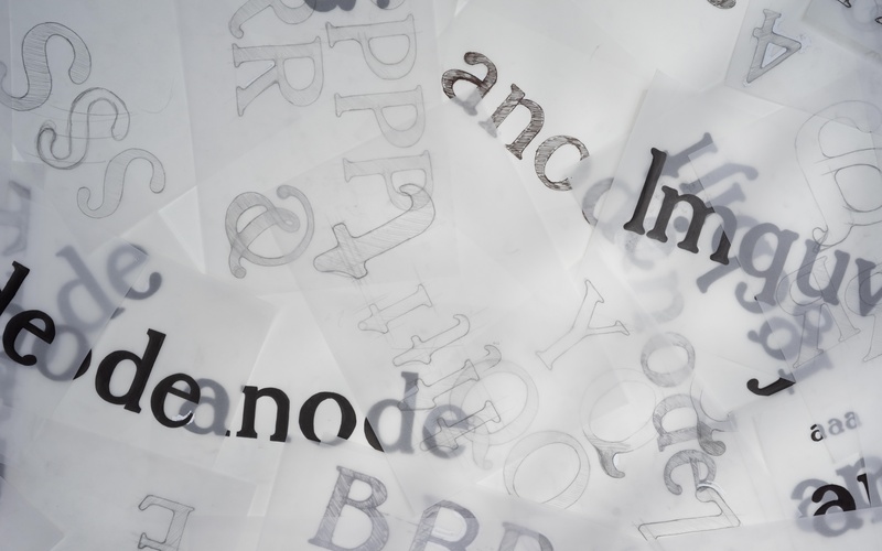 Zu sehen sind Buchstaben auf transparentem Papier. 