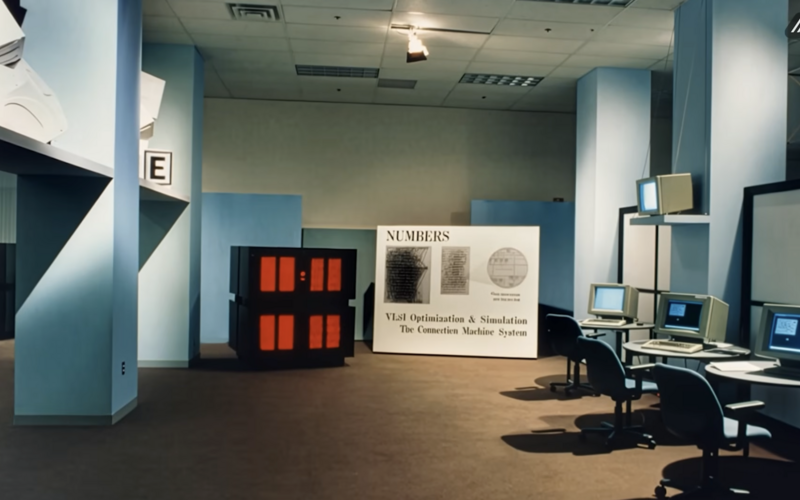 Zu sehen ist ein Raum mit Bürostühlen, Computern und einer Connection Machine. 