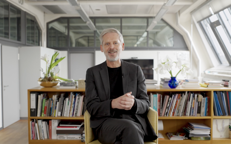 Zu sehen ist ein Video Thumbnail, das Alistair Hudson in einem Büro zeigt.