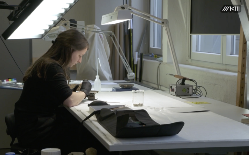Zu sehen ist eine Person, die an der Restaurierung eines Kunstwerks arbeitet.